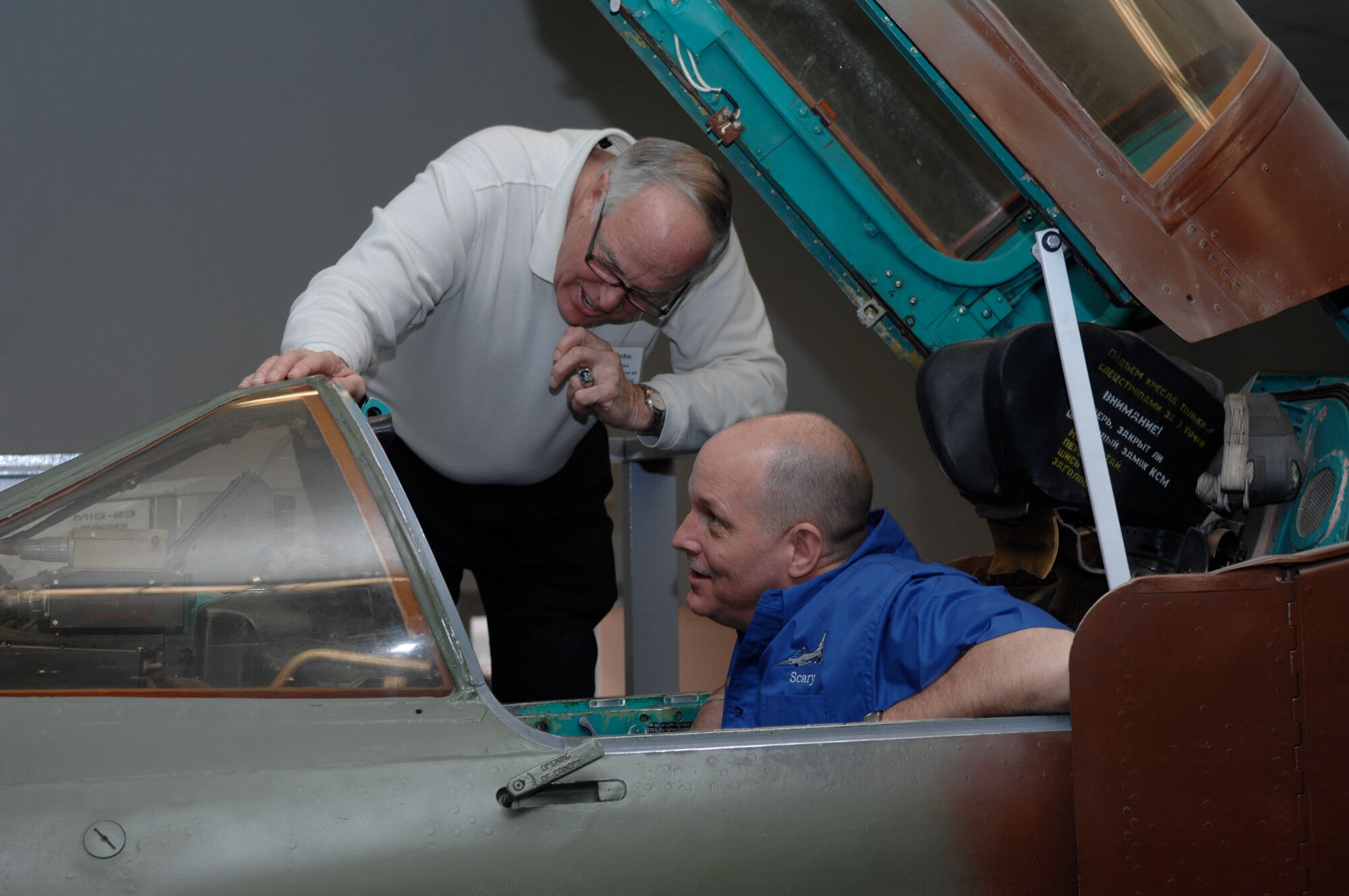 NELLIS AIR FORCE BASE, Nev. -- Lieutenant Col. Doug "Scary" Schaare, former 55th Fighter Squadron "Shooters" pilot (right), and retired Air Force Lt. Col. John Peebles, a Shooter alumnus, check out a MiG-23 Flogger F aircraft static display at the threat training facility March 6. Nearly 20 Shooter alumni from every decade since World War II joined current squadron members for a reunion. (U.S. Air Force photo/2nd Lt. Emily Chilson)