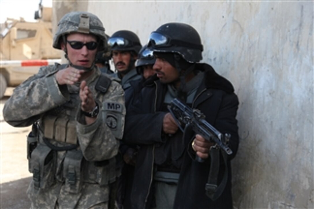 A U.S. Army soldier from the 118th Military Police Company teaches a class on room clearing to a group of Afghan National Police officers at Pole-Elam District Center in Logar province, Afghanistan, on March 4, 2010.  