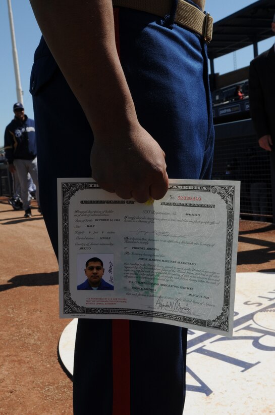 Cpl. Jorge Martinez, Marine Attack Squadron 214 airframer, stands with his certificate of citizenship at the Peoria Sports Complex in Peoria, Ariz., March 10, 2010. Both he and Cpl. Marvin Medeiros, Headquarters and Headquarters Squadron food service specialist, received their certificates during a ceremony before a San Diego Padres and Milwaukie Brewers game. Martinez and his family immigrated to the U.S. from Mexico in 1986, while Medeiros emigrated from Peru in 2000. Both Marines are based at the Marine Corps Air Station in Yuma, Ariz.