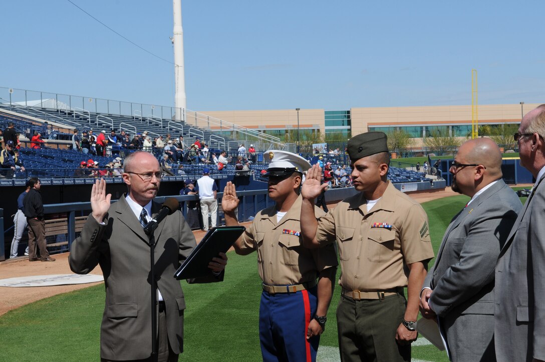 Cpl. Jorge Martinez, left, Marine Attack Squadron 214 airframer, and Cpl. Marvin Medeiros, Headquarters and Headquarters Squadron food service specialist, recite the oath of citizenship at a ceremony at the Peoria Sports Complex in Peoria, Ariz., March 10, 2010. Martinez and his family immigrated to the U.S. from Mexico in 1986, while Medeiros emigrated from Peru in 2000. Both Marines are based at the Marine Corps Air Station in Yuma, Ariz.