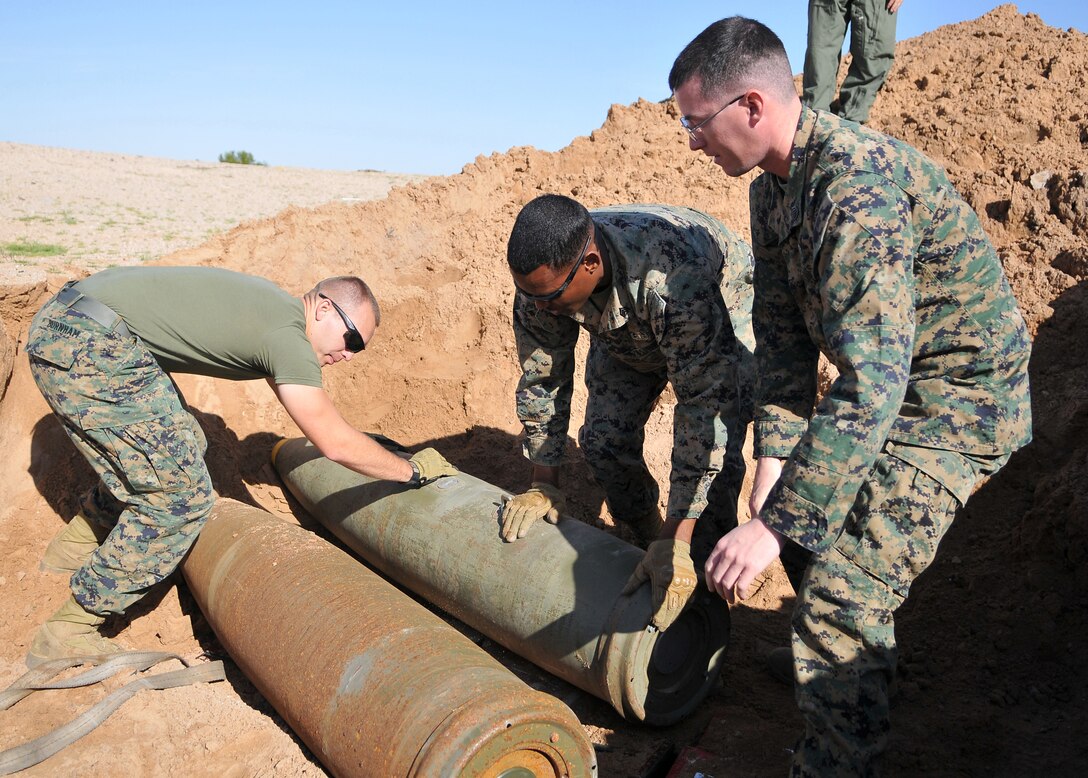 Sgt. Brenden Burnham, explosive ordnance disposal on-the-job trainee assists station EOD technicians Sgt. Cassell Wiggins and Staff Sgt. Joshua Gagne in placing two MK-83 1,000-pound bombs in position to be detonated at the munitions treatment range on the Barry M. Goldwater Range east of Yuma, Ariz., March 10, 2010. Members of the station EOD team disposed of more than 6,000 pounds of ordnance that was unsafe to be used. The cache consisted of six MK-83s and several thousand rounds of various small-caliber munitions, which had become unserviceable. “Being able to train with the team before I go to the schoolhouse has given me the opportunity to learn a lot,” said Burnham. “I’m really grateful for the opportunity.” The team safely disposed of the ordnance in three separate blasts occurring one minute apart from one another. Detonating all of the ordnance at once would risk it being felt by the city of Yuma, approximately 5 miles away, said Gunnery Sgt. Michael Chapman, station EOD team leader.