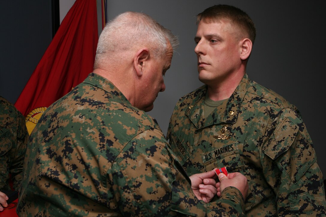 Maj. John A Moder, the officer-in-charge of Assessment and Selection, Marine Special Operations School, U.S. Marine Corps Forces, Special Operations Command, is awarded a Bronze Star Medal with combat distinguishing device by Maj. Gen. Paul E. Lefebvre, the commander of MARSOC, during a ceremony inside the MARSOC headquarters building on March 10. Moder received the award for heroic achievement in connection with combat operations while serving as the commanding officer of C Company, Battalion Landing Team, 1st Battalion, 6th Marine Regiment, 24th Marine Expeditionary Unit, II Marine Expeditionary Force, in the Garmsir District, Helmand Province, Afghanistan on May 30, 2008.