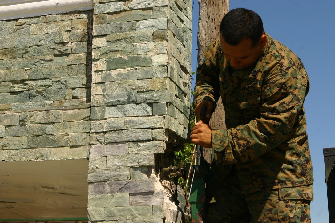 Staff Sgt. Jose Cerca, motor transport chief with Combat Logistics Battalion 31 (CLB-31), 31st Marine Expeditionary Unit (MEU), saws a bolt off of a gate during a gate repair, March 11. The MEU is currently participating in Exercise Balikatan 2010 (BK ’10). Servicemembers from the Armed Forces of the Philippines (AFP) and the 31st MEU are training together during BK ’10 to hone their civil-military interoperability skills to ensure more responsive, efficient and effective relief efforts. (Official Marine Corps photo by Cpl. Michael A. Bianco)