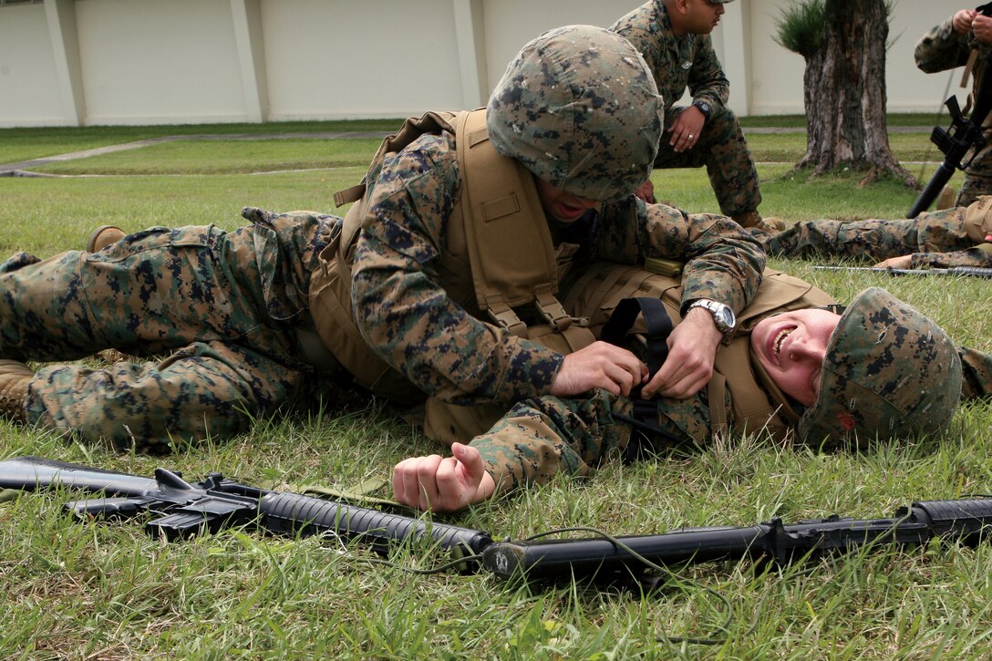 Seaman Lance Brown provides medical attention to simulated casualty, Seaman Apprentice David Thurkill during the Tactical Combat Casualty Care course at Camp Hansen March 12. Brown and Thurkill are both corpsman with 3rd Medical Battalion, 3rd Marine Logistics Group, III Marine Expeditionary Force.