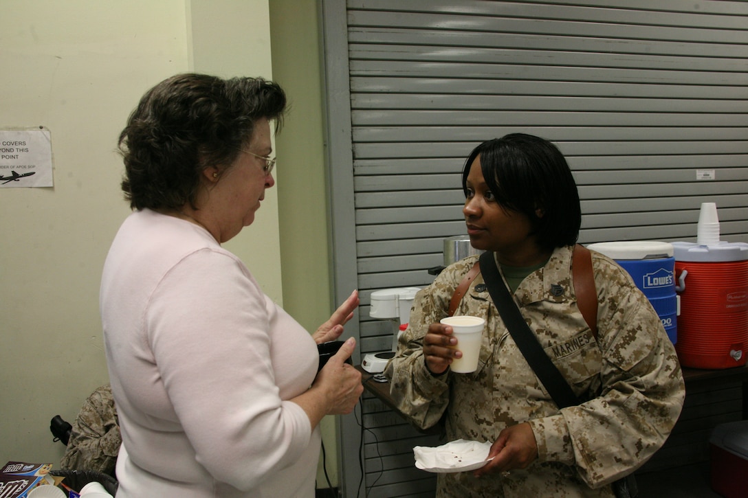 Nancy S. White, a former Marine Corps sergeant, speaks to Kimberly A. Stigler, an armory chief with Marine Wing Support Squadron 274, as she waits for her squadron to deploy overseas, March 11. White and her husband often bring drinks and snacks to Marines waiting to deploy from the Aerial Port of Embarkation.
