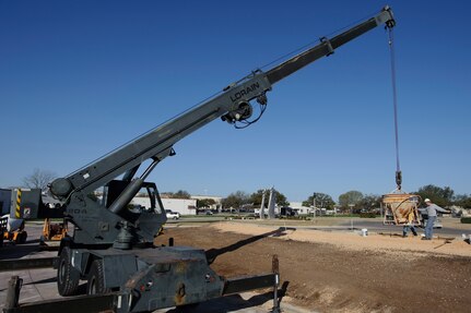 Cement finishers and heavy equipment operators from the 902nd Civil Engineer Squadron position a cement-filled bucket over a form March 11 during the replacement of the Randolph Field letters facing Washington Circle. (U.S. Air Force photo by Steve Thurow)