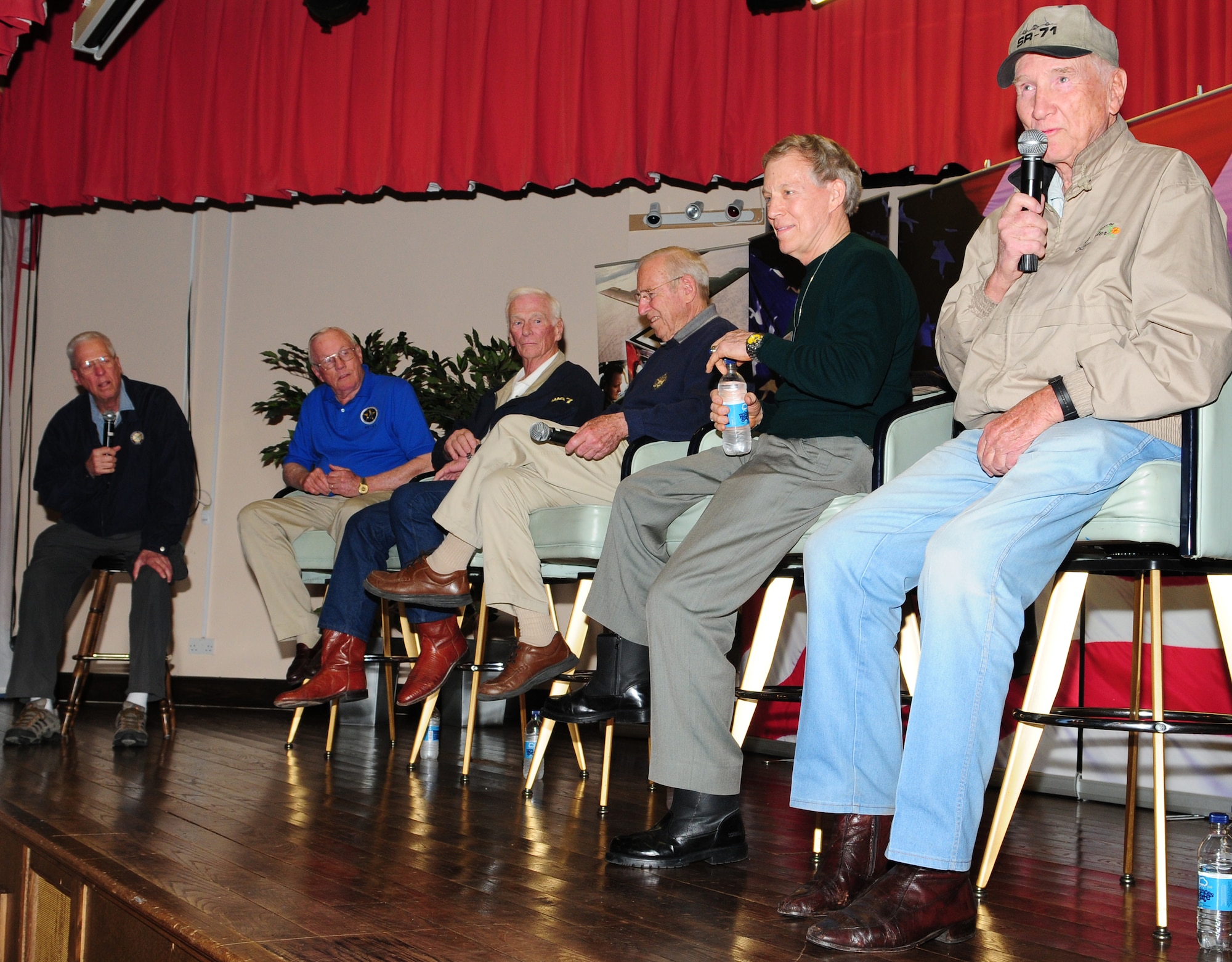 RAF MILDENHALL, England – Bob Gilliland (right), SR-71 chief test pilot, describes the awesome speed of the Blackbird to a crowd of more than 1,000 spectators during a “Legends of Aerospace: The Impossible Is Possible” tour at RAF Mildenhall’s Galaxy Club March 11. With Mr. Gilliland (left to right) were: Former “Good Morning America” host, David Hartman; first astronaut to walk on the moon, Neil Armstrong; last astronaut to walk on the moon, Gene Cernan; Apollo 13 commander, Jim Lovell; and last Air Force pilot ace, Steve Ritchie.  (U.S. Air Force photo/Karen Abeyasekere)
