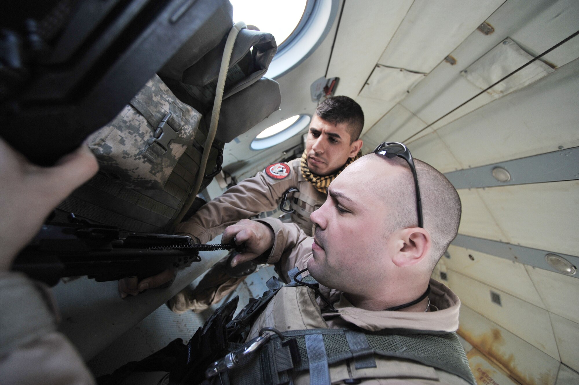 Tech. Sgt. Ethan Masslow and Iraqi air force aerial gunner Athier Fiaz preflight a machine gun onboard an Mi-17 helicopter March 2, 2010, at Camp Taji, Iraq. Sergeant Masslow is deployed from Malmstrom Air Force Base, Mont. (U.S. Air Force photo/Staff Sgt. Quinton Russ)