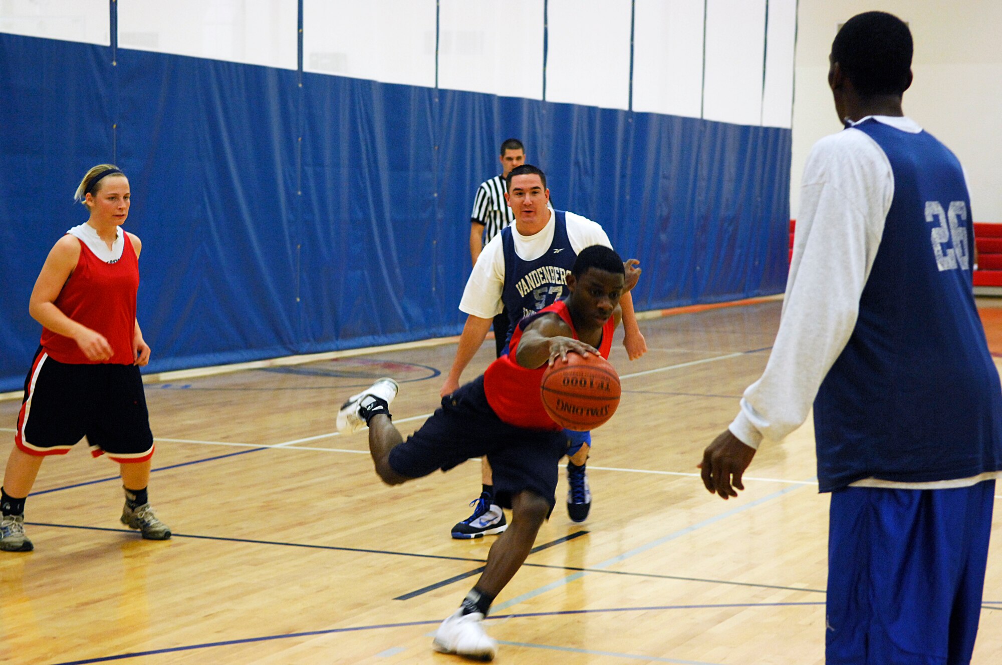 VANDENBERG AIR FORCE BASE, Calif. -- Shaw, of the 381st Training Group, maneuvers around his opponents trying to help his team score during an intramural game here Monday, March 8, 2010. The381st TRG was defeated by the 30th Launch Group 72-44. (U.S. Air Force photo/Airman 1st Class Heather R. Shaw)







