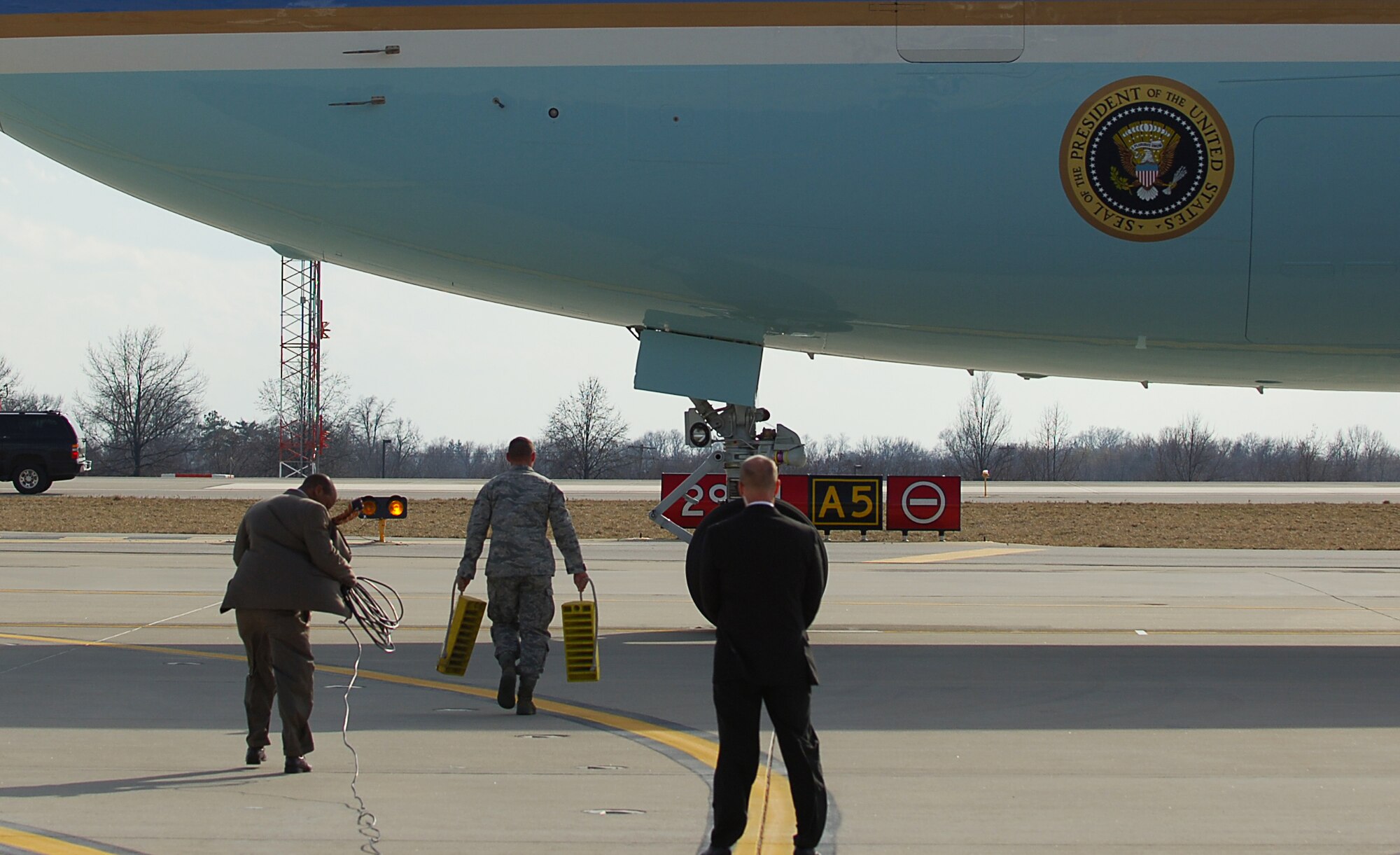 SCOTT AIR FORCE BASE, Ill. -- An Airman from the 932nd Maintenance Squadron carries wheel chalks out to Air Force One as it arrives with President Barack Obama March 10, 2010 at St. Louis - Lambert International Airport. Airmen from the 375th Logistics Readiness Squadron and the 932nd Maintenance Squadron provided refueling and vehicle maintenance support to Air Force One for the president’s visit to St. Louis. (U.S. Air Force photo by Senior Airman Ryan Crane)