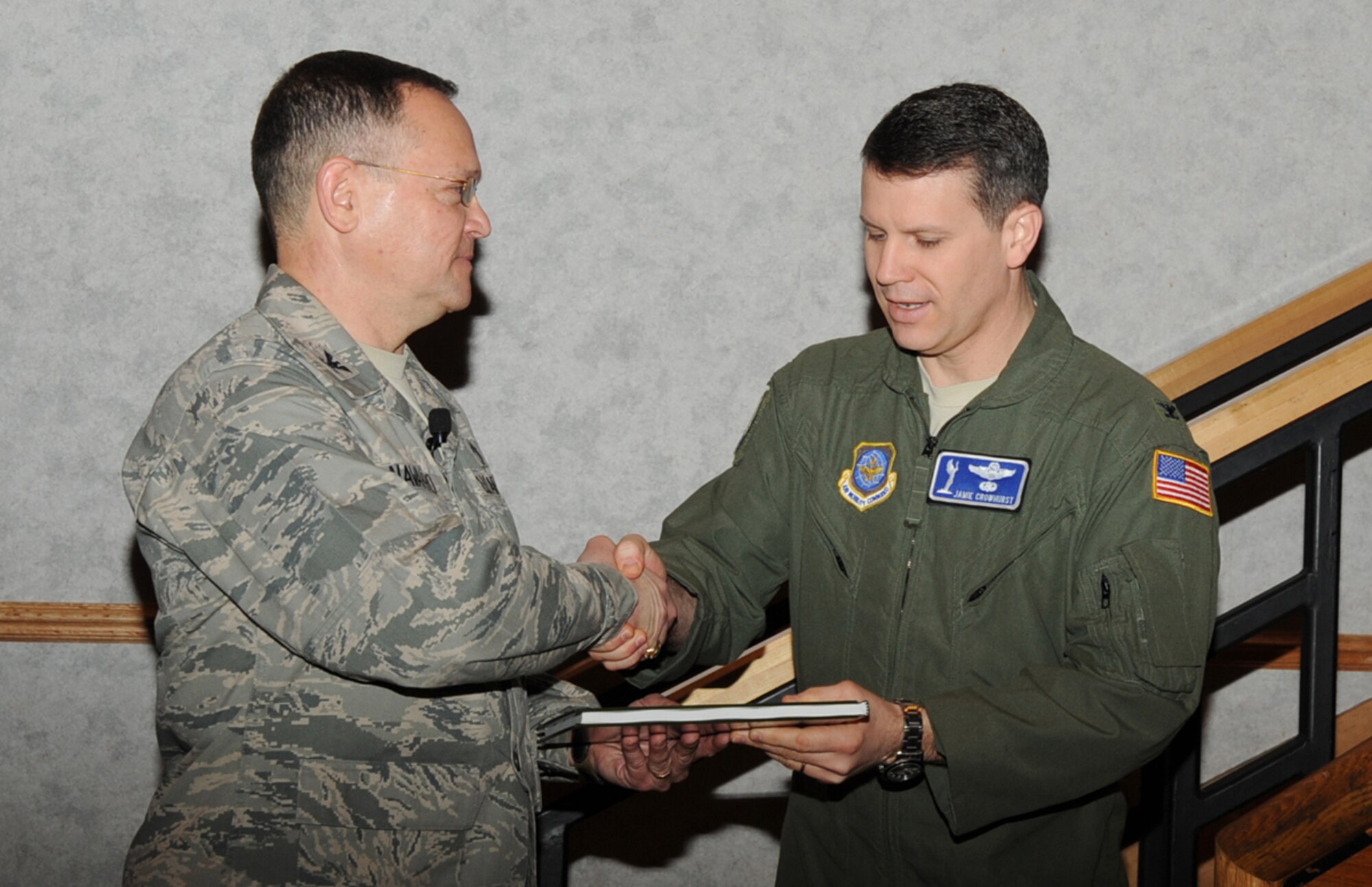 U.S. Air Force Chaplain (Col.) Conrado Navarro, U.S. Transportation Command and Air Mobility Command chaplain, receives a book, “A Saint Among Us,” by the Father Kapaun Guild and a Father Emil Kapaun coin, from Col. James Crowhurst, 22nd Air Refueling Wing commander, during the National Prayer Breakfast at the Robert J. Dole Community Center ballroom, Mar. 9, 2010, at McConnell Air Force Base, Kan. (U.S. Air Force Photo/Senior Airman Maria Ruiz)