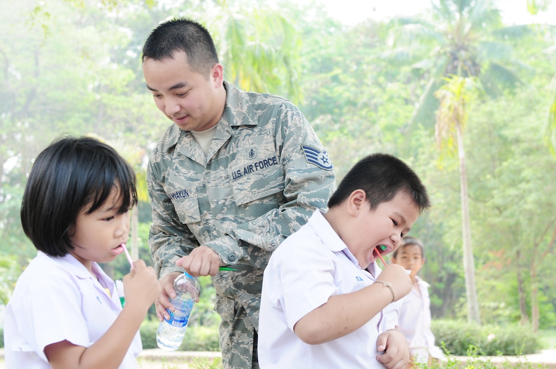 Staff Sgt. Watthanakit Wannakun demonstrates proper dental cleaning techniques for two school children during a Cope Tiger 2010 medial civic assistance project March 9, 2010, in Thailand. Sergeant Wannakun is assigned to 18th Medical Group at Kadena Air Base, Japan. (U.S. Air Force photo/Capt. Genieve David)
