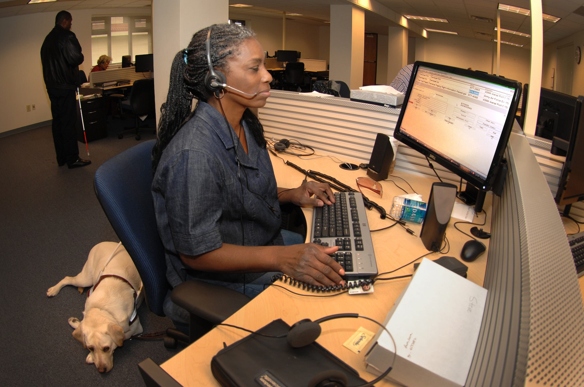 Beverly Redic employs Job Access with Speech, an interactive screen reader with text-to-speech capabilities to help a customer at the new Telephone Consolidated Operatior Center at Travis. (U.S. Air Force photo/Nan Wylie)