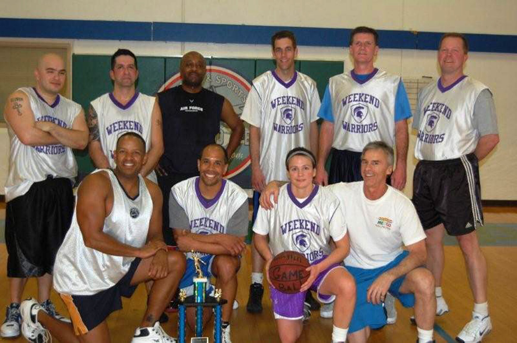 JOINT BASE LEWIS-MCCHORD, Wash.- Reservists from the 446th Airlift Wing Weekend Warrior basketball team in the 30-and-over intramural league, celebrate their third-place overall finish in the tournament, March 10, at the JBLM Fitness Center here. The Warriors ended up losing their last two playoff games after starting the season 13-0. Pictured from left, front row: Derek Bryant, Martin Oliver, Heidi Hancock, and Marlon Berger (Hancock's husband). Back row from left: Rob Jimenez, Stephan Rude, Lawrence Broussard (a pick up from the 62nd Force Support Squadron), William Budge, Brian Eyre, and Lane Seaholm. (U.S. Air Force photo/Tech. Sgt. Joe Ramos)