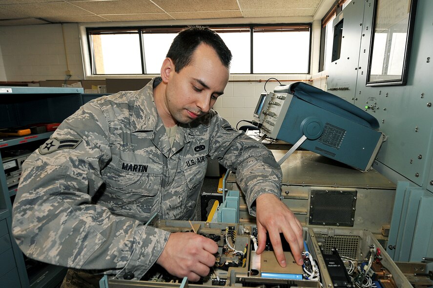 OFFUTT AIR FORCE BASE, Neb. – Airman 1st Class Devin Martin, a cyber transport journeyman with the 55th Strategic Communications Squadron, cleans the memory storing unit in the central maintenance test set inside Bldg. 465 here March 8. Airman Martin was recently selected as one of 10 male vocalists for the 2010 Tops in Blue tour. U.S. Air Force photo by Charles Haymond