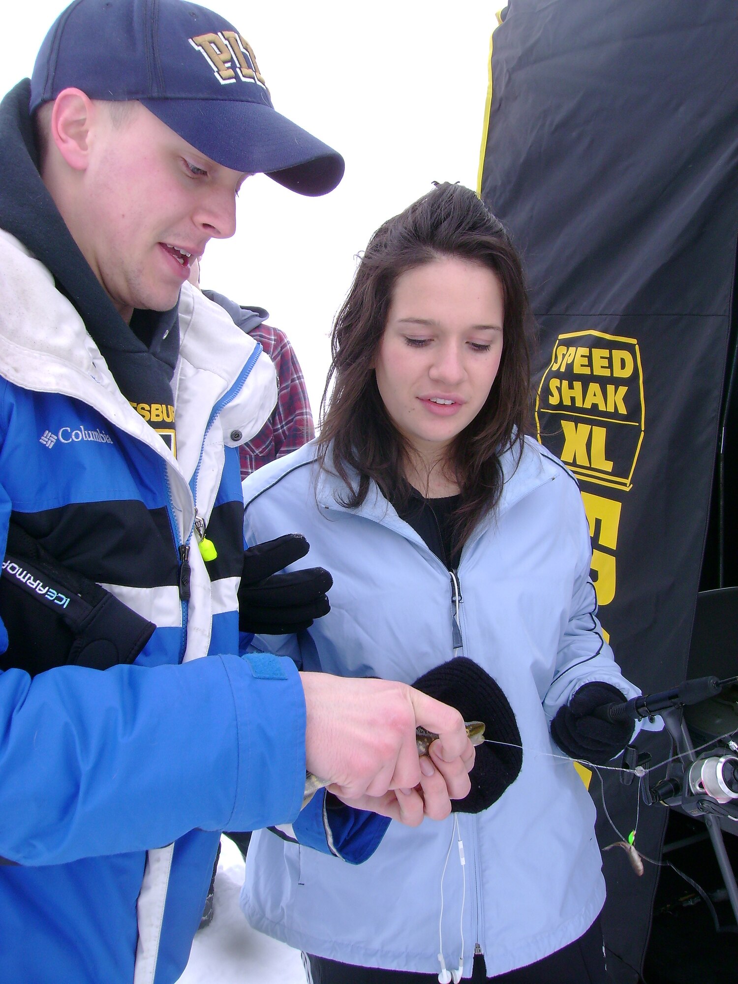Senior Airman Matthew Portka, 319th Civil Engineer Squadron Fire Department, helps Airman Margarita Botero, 319th Medical Group, remove a Yellow Perch from her line March 6 in Larimore, N.D. Airman Botero caught the perch during an ice fishing trip sponsored by the Grand Forks Air Force Base Outdoor Recreation Center. For more information on the Outdoor Recreation Center, call (701) 747-3688 or log on to http://www.forksupport.com/odr.htm. (U.S. Air Force courtesy photo)