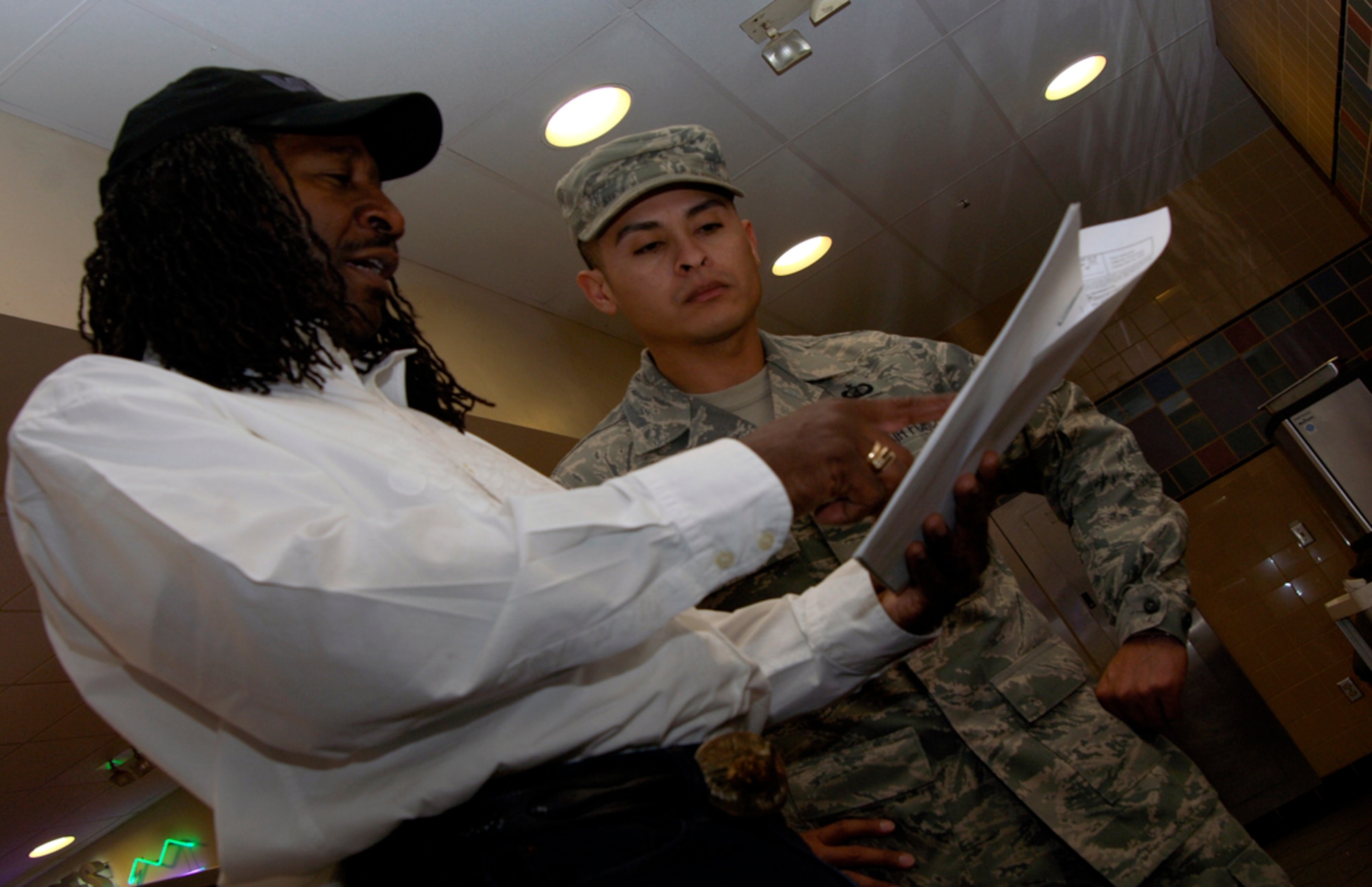 U.S. Air Force Tech. Sgt. Edgardo Pineda, 22nd Contracting Squadron contract services specialist, verifies a vendor work equipment list with Roger Miller, Watson Services project manager, at the dining facility March 5, 2010, at McConnell Air Force Base, Kan.The services team oversees all base contractors to ensure their mission is accomplished. (U.S. Air Force photo/Staff Sgt. Anthony Mejia)