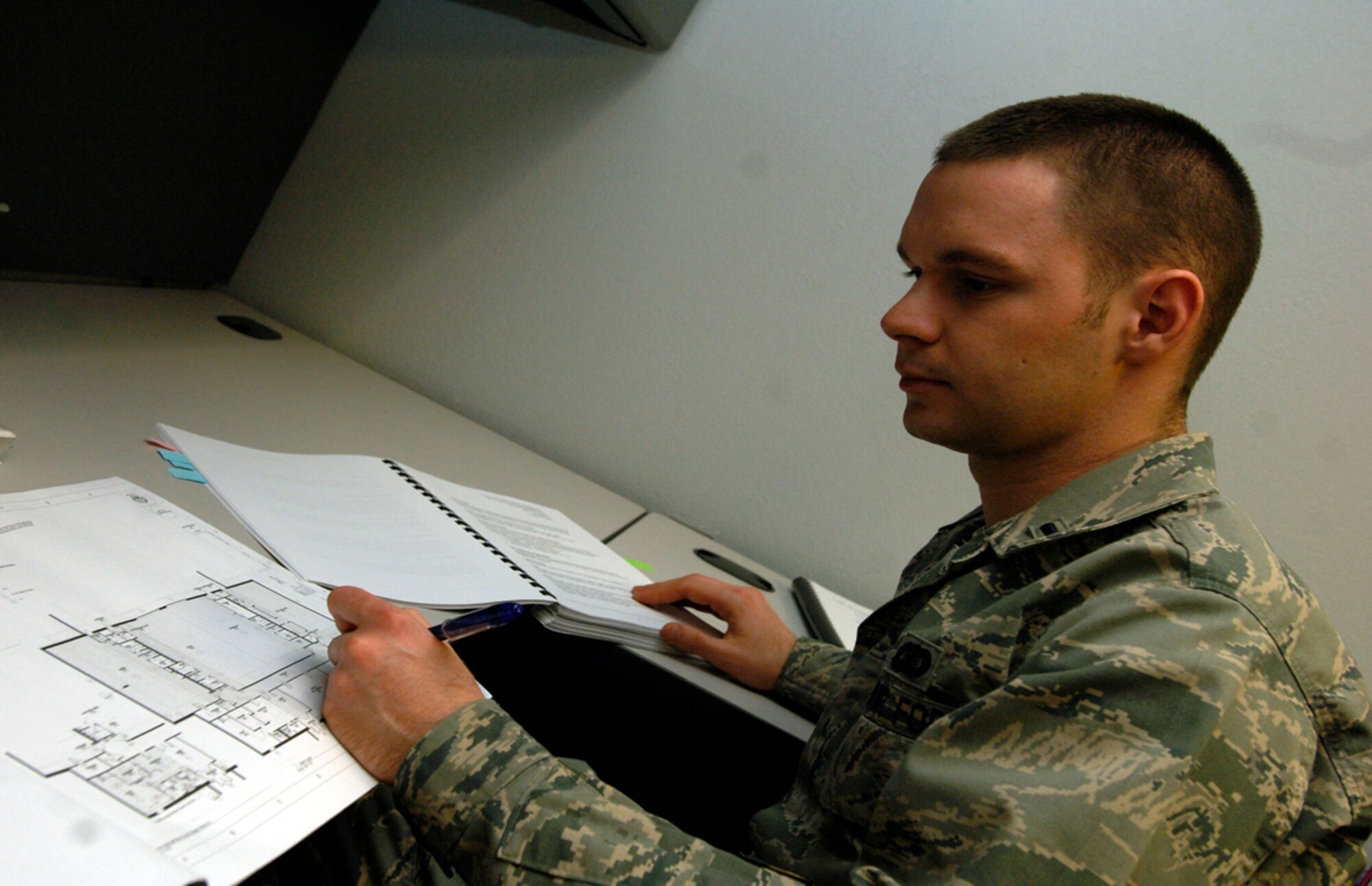 U.S. Air Force 1st Lt. Craig Stevenson, 22nd Contracting Squadron constructions team OIC, reviews building plans at McConnell Air Force Base, Kan., March 5. The 22nd CONS is composed of three teams, the construction team, services team and the simplify acquisition team.  The 22nd CONS processes approximately 900 contracts per year. (U.S. Air Force photo/Staff Sgt. Anthony Mejia)
