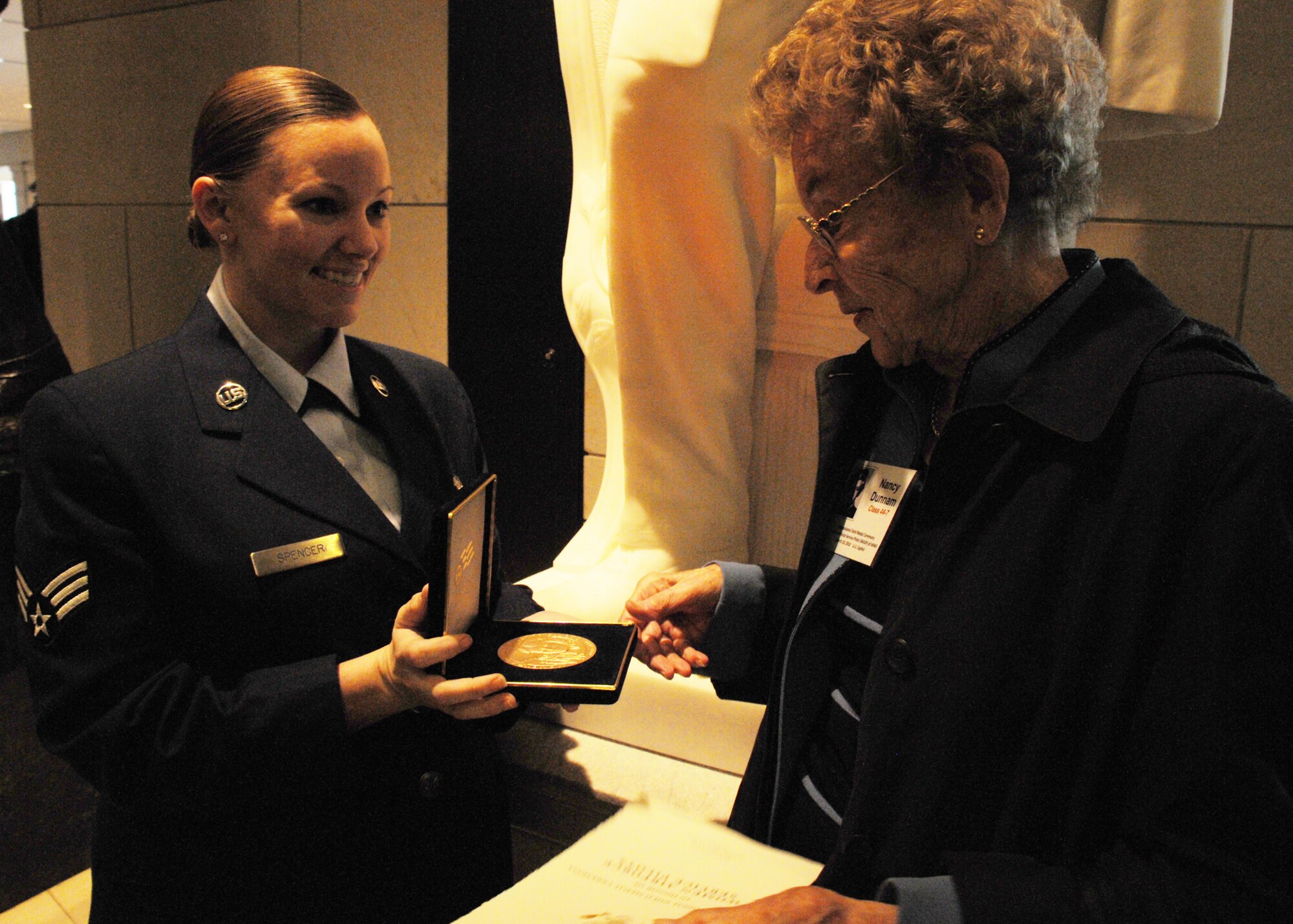 Senior Airman Katie Spencer, 316th Wing public affairs specialist, left, presents Nancy Dunnham, World War II Woman Airforce Service Pilot, with a bronze replica of the Congressional Gold Medal in a private ceremony at the Capitol building visitor center March 10, 2010. Ms. Dunnham is from Bellevue, Wash., and served as part of the “Caterpillar Club,” a skydive team that jumped from simulated burning and damaged aircraft. 
A number of Joint Team Andrews Airmen volunteered to escort the WASP and assisted them and their families during the day. (U.S. Air Force photo by Airman 1st Class Kat Lynn Justen)