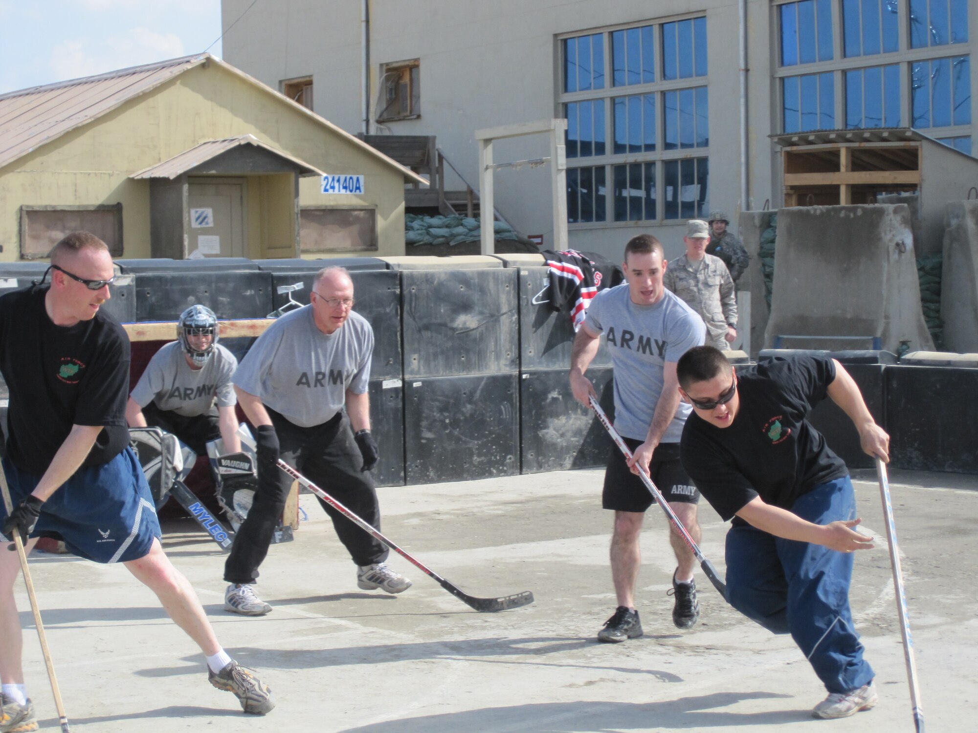 Air National Guard members of the 148th Fighter Wing Civil Engineering Squadron and the Army Reserve 372nd Engineering Battalion enjoy a game of floor hockey during a tournament held at Bagram Airfield, Afghanistan in honor of the 2010 Minnesota High School State Hockey Tournament on Sunday, March 7, 2010.  (Photo by MN National Guard)