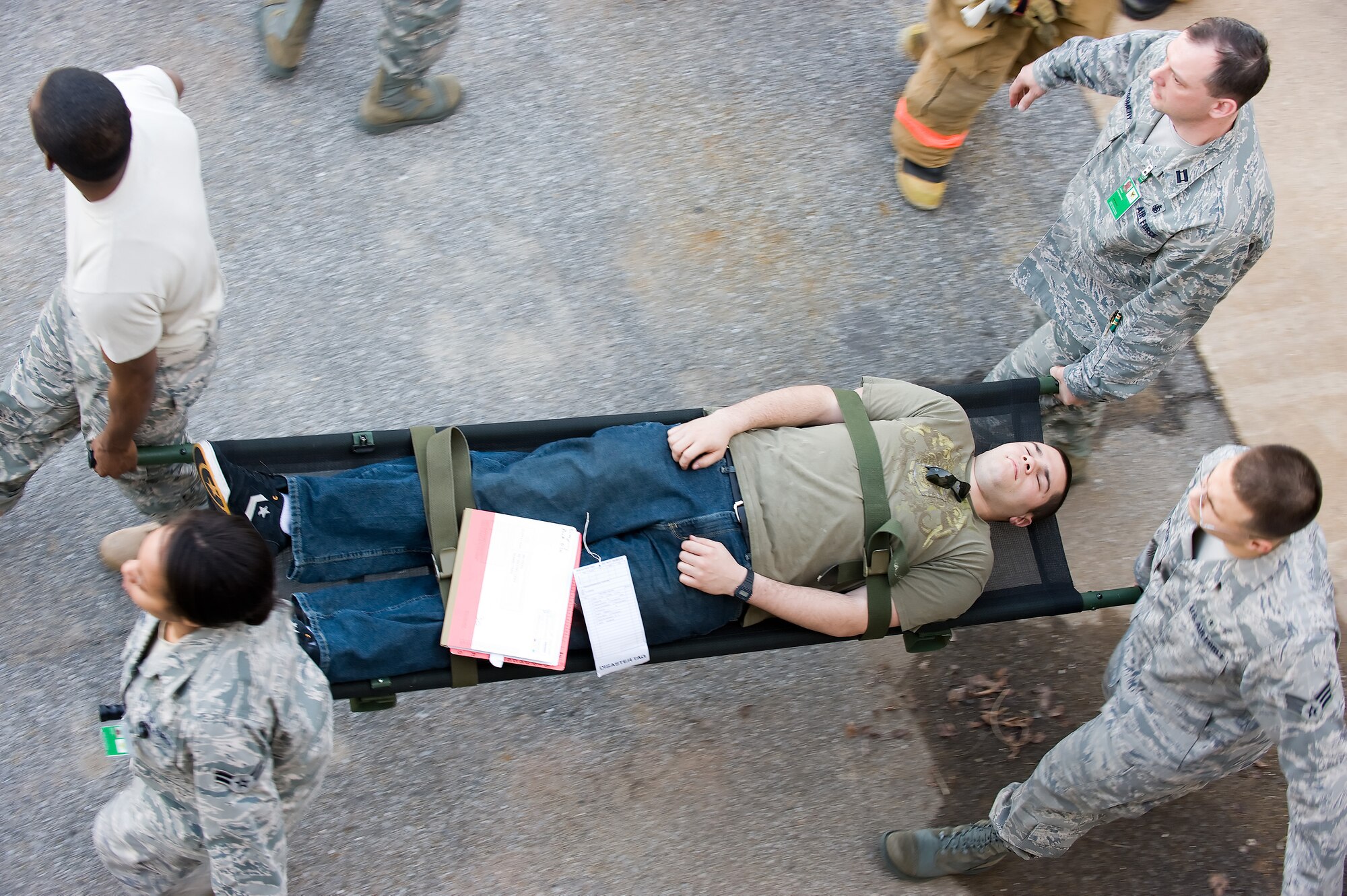 Airman 1st Class Christopher Saunders, 436th Aircraft Maintenance Squadron, plays the part of an accident victim as members of the 436th Medical Group carry him to safety.  Dover Air Force Base participated in a three-day training exercise to ensure personnel are trained and prepared for any situation.   (U.S. Air Force photo/Jason Minto)