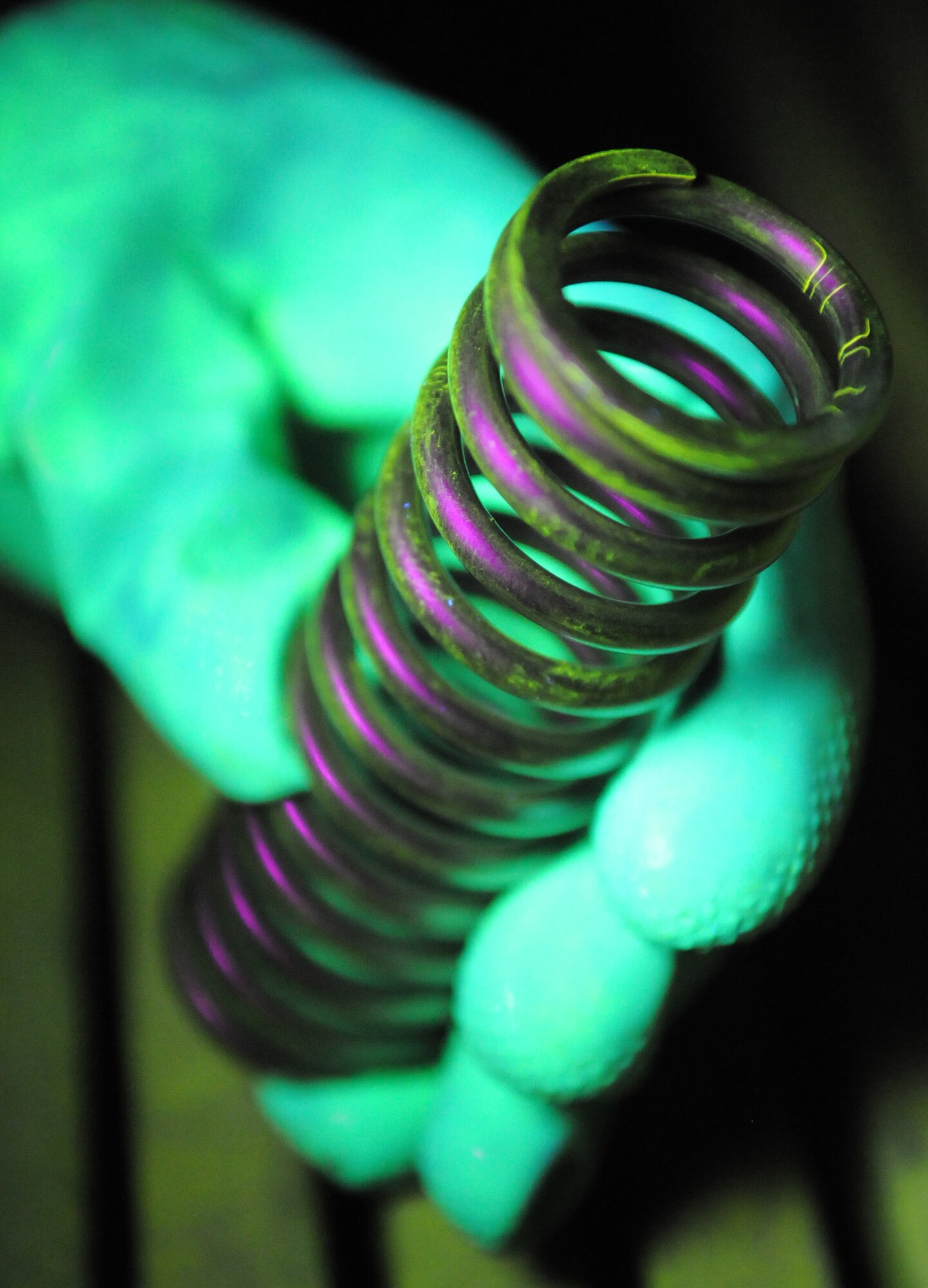 RAF MILDENHALL, England – Cracks glow on a spring under a black light after being run through a magnetic particle machine at the non-destructive inspection shop March 9. NDI is crucial in identifying defective aircraft parts to prevent possible failure due to microscopic cracks and fractures on the surface or internally. (U.S. Air Force photo/ Staff Sgt. Jerry Fleshman)