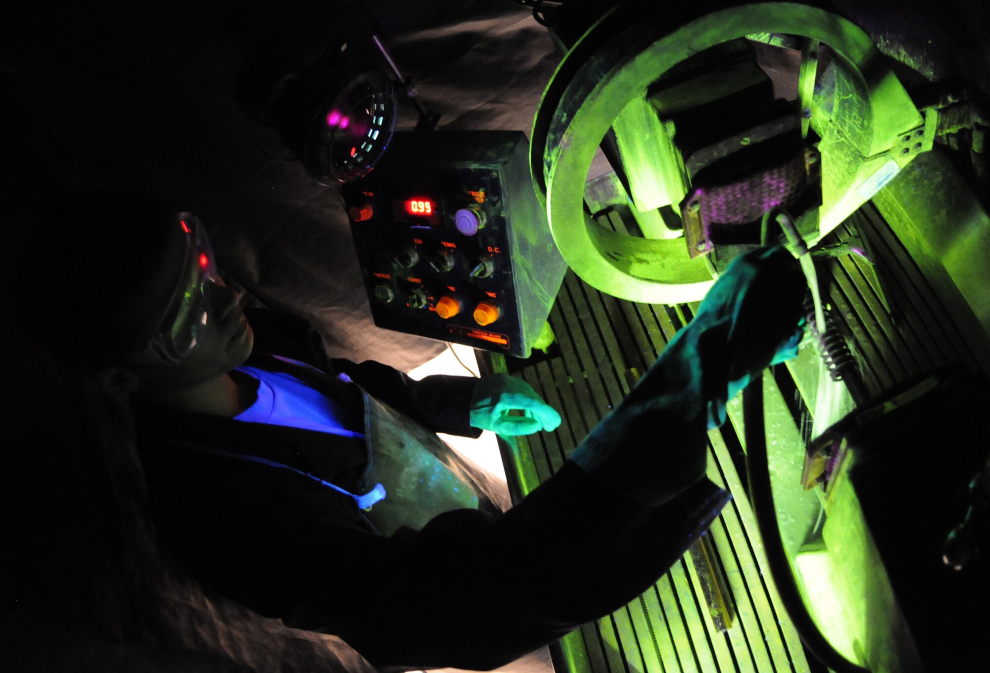 RAF MILDENHALL, England – Airman 1st Class Christopher Bovill, 100th Maintenance Group Non-Destructive Inspection technician, pours a microscopic iron solution over a spring inside the magnetic particle machine at the NDI shop March 9. (U.S. Air Force photo/ Staff Sgt. Jerry Fleshman)