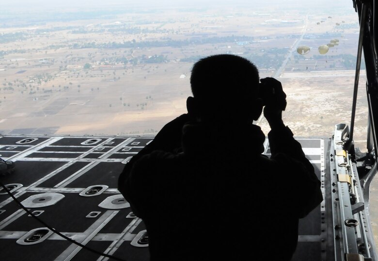 OVER PHNOM PENH, Kingdom of Cambodia -- A jumpmaster from the Royal Cambodian Armed Forces records RCAF soldiers as they parachute from the back of a MC-130P Combat Shadow here Feb. 22. Airmen from the 353rd Special Operations Group deployed here Feb. 21-24 to support a training exercise between U.S. Army Special Forces and Royal Cambodian Armed Forces National Counter-Terrorism Special Forces. More than 90 U.S. and RCAF soldiers combined to mark the first-ever combined airdrop between U.S. and Cambodian forces. (U.S. Air Force photo by Tech. Sgt. Aaron Cram)