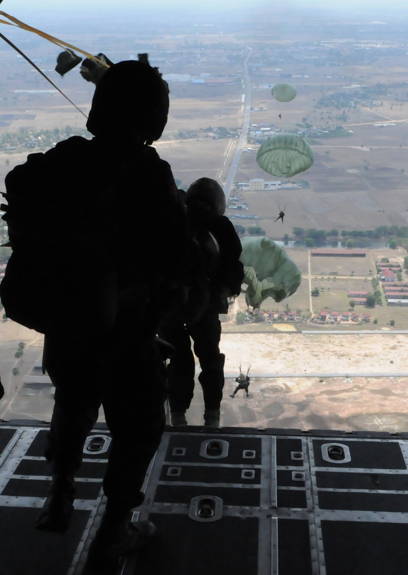 OVER PHNOM PENH, Kingdom of Cambodia -- Members of the Royal Cambodian Armed Forces National Counter-Terrorism Special Forces parachute from the back of a MC-130P Combat Shadow here Feb. 22. More than 90 U.S. and RCAF soldiers combined to mark the first-ever combined airdrop between U.S. and Cambodian forces. It was also the first-ever airdrop for NCTSF soldiers. U.S. Army Special Forces spent five weeks training the fledgling RCAF National Counter-Terrorism Special Forces. (U.S. Air Force photo by Tech. Sgt. Aaron Cram)