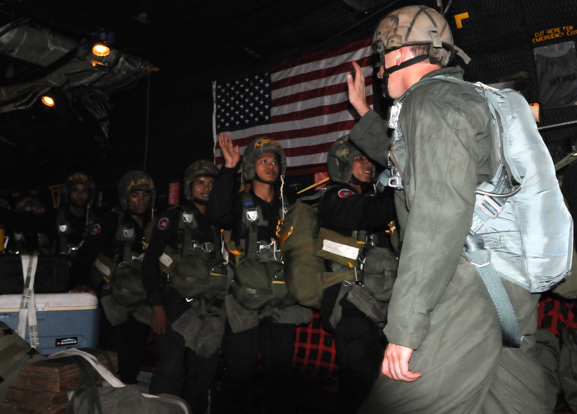 OVER PHNOM PENH, Kingdom of Cambodia -- A jumpmaster from the U.S. Army Special Forces high fives Royal Cambodian Armed Forces National Counter-Terrorism Special Forces members before they parachute from the back of a MC-130P Combat Shadow here Feb. 22. More than 90 U.S. and RCAF soldiers combined to mark the first-ever combined airdrop between U.S. and Cambodian forces. It was also the first-ever airdrop for NCTSF soldiers. (U.S. Air Force photo by Tech. Sgt. Aaron Cram)