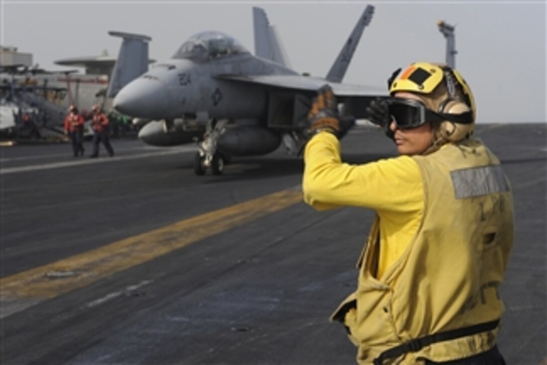 U.S. Navy Petty Officer 1st Class Juan Ramos directs an aircraft during flight operations aboard the aircraft carrier USS Dwight D. Eisenhower (CVN 69) underway in the North Arabian Sea on March 7, 2010.  The Eisenhower is on a six-month deployment as a part of the ongoing rotation of forward-deployed forces supporting maritime security operations.  