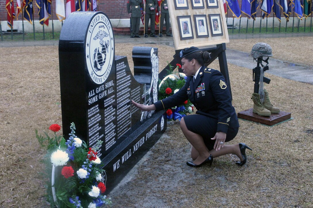 Army Staff Sgt. Beatriz Alberts, mother of fallen Marine Lance Cpl. Christopher S. Baltazar Jr., touches her son’s name that is engraved on the 2nd Light Armored Reconnaissance Battalion, 2nd Marine Division, memorial wall. Family members, friends, Marines and sailors gathered to remember five Marines and one sailor with 2nd LAR who paid the ultimate sacrifice, during Operation Enduring Freedom, at a memorial service aboard Marine Corps Base Camp Lejeune N.C., March 12, 2010.