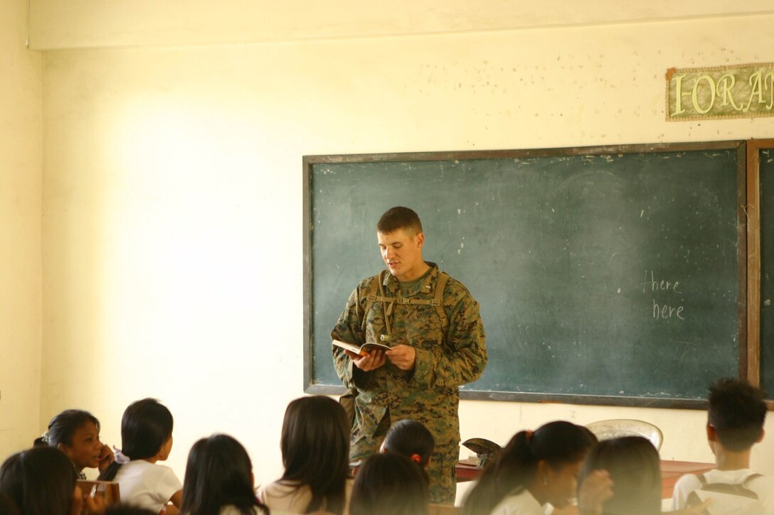 1st Lt. Preston Walker, training officer for Combat Logistics Battalion 31 (CLB-31), 31st Marine Expeditionary Unit (MEU), reads to students from St. Juliana High School during a community relations (COMREL) event, March 12. CLB-31 took an operational pause during exercise Balikatan 2010 (BK ’10) to build bridges of friendship with the local community.