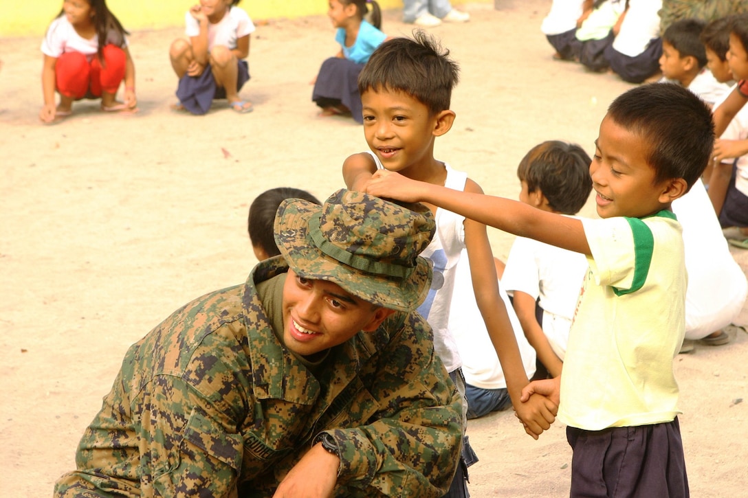 Lance Cpl. Christopher Gudiel, a military policeman with Combat Logistics Battalion 31 (CLB-31), 31st Marine Expeditionary Unit (MEU), plays a game with St. Juliana Elementary School students during a community relations (COMREL) event, March 12.  CLB-31 took an operational pause during exercise Balikatan 2010 (BK ’10) to build bridges of friendship with the local community.