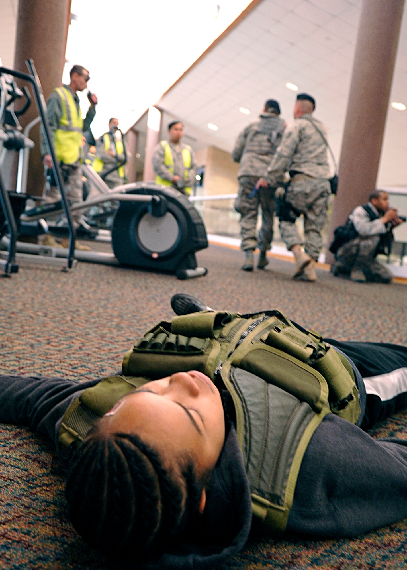 HOLLOMAN AIR FORCE BASE, N.M. -- Senior Airman Lauren Moss, 49th Aeromedical Dental Squadron, role-plays a deceased gunman at the Domenici Fitness and Sports Center after security forces personnel take control of the situation, March 11, 2010, during exercise Coronet Gold Rush 10-02. The active shooter exercise helped prepare the 49th Fighter Wing members for future exercises and possible real-world situations. (U.S. Air Force photo by Staff Sgt. Anthony Nelson Jr.)