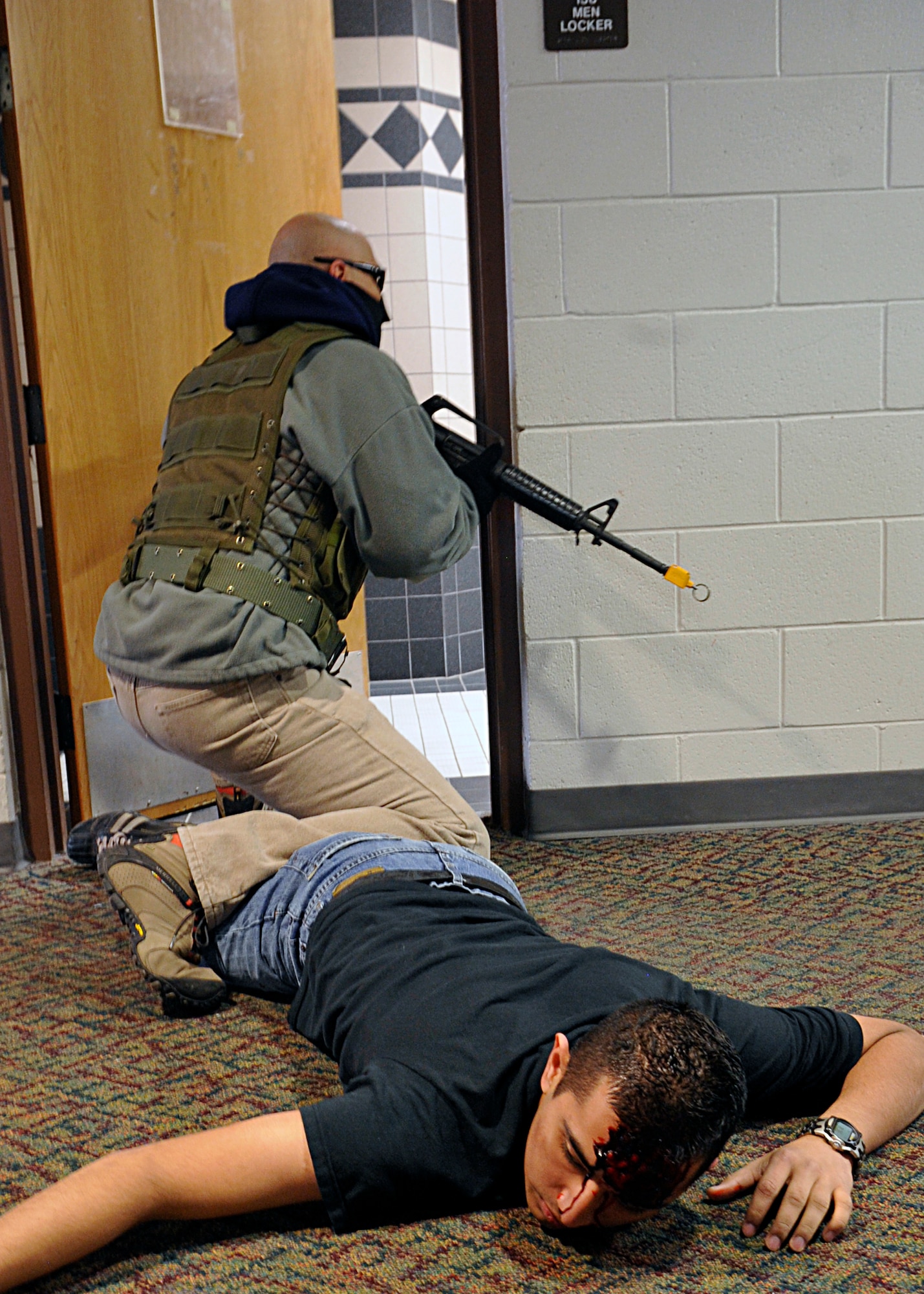 HOLLOMAN AIR FORCE BASE, N.M. -- An armed gunman, played by Tech. Sgt. David Loera, 49th Material Maintenance Group, invades the Domenici Fitness and Sports Center's men's locker room, March 11, 2010, during exercise Coronet Gold Rush 10-02. The active shooter exercise is one of the most comprehensive and involved emergency preparation activities planned by the 49th Fighter Wing's plans and inspections office. (U.S. Air Force photo by Staff Sgt. Anthony Nelson Jr.)