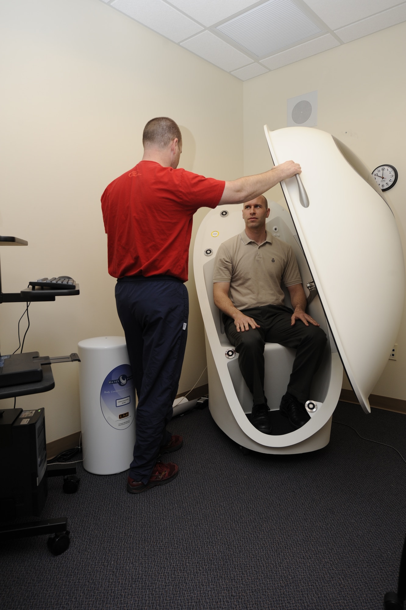 MOUNTAIN HOME AIR FORCE BASE, Idaho – Richmond Myhre, Health and Wellness Center exercise physiologist, prepares Mark Tschampl, HAWC health promotion manager, for his session in the Bod Pod. The Bod Pod, recently acquired by the HAWC, calculates total body fat and basal metabolic rate, or metabolism at rest. The Bod Pod is the current gold standard in weighing body fat composition. The HAWC staff wants all Gunfighters: active-duty, spouses and civilians, to know the Bod Pod is available to use as part of their fitness program. (U.S. Air Force photo by 1st Lt. Neil Samson)

