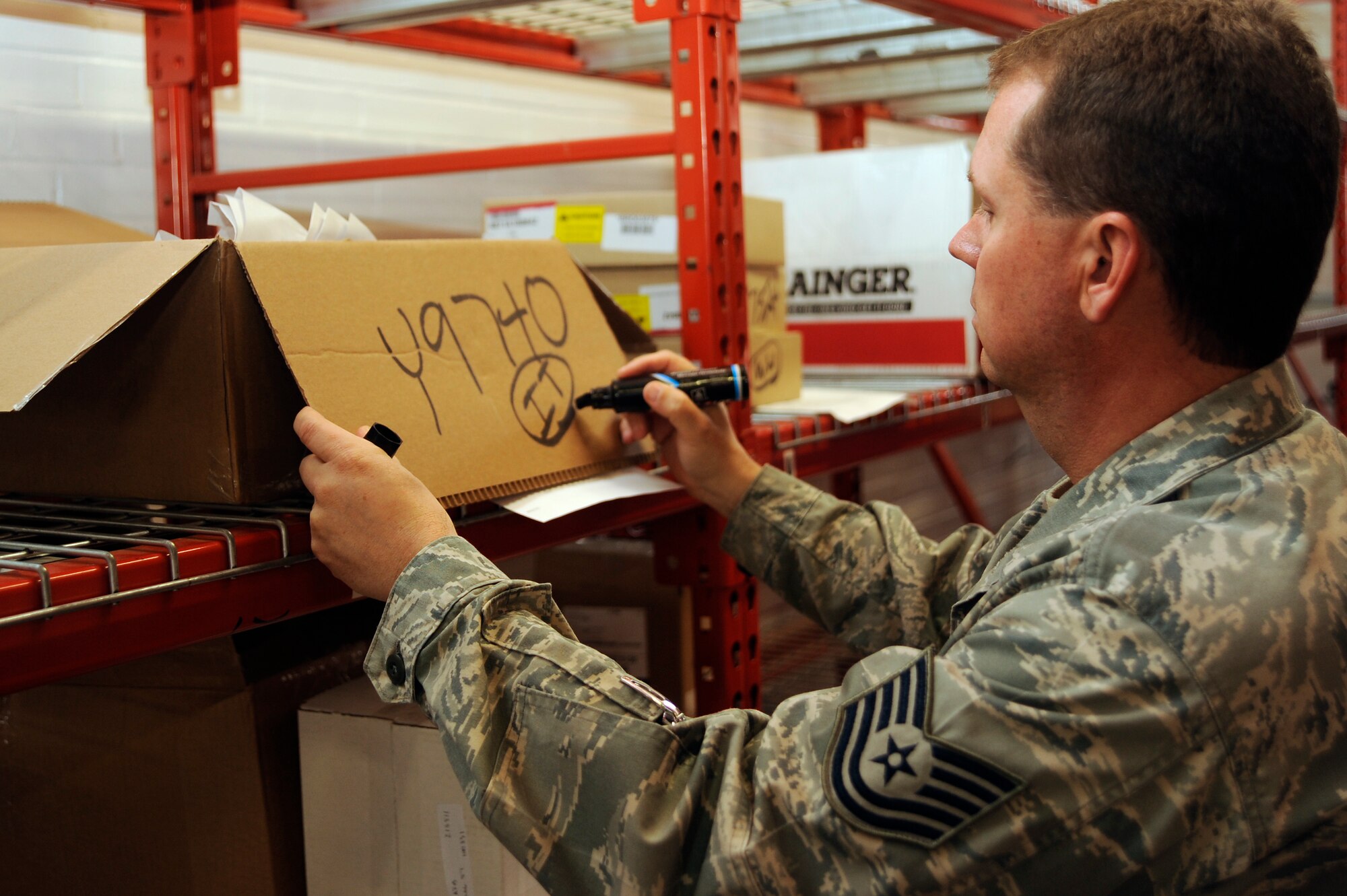 SCOTT AIR FORCE BASE, Ill -- Tech. Sgt. Christopher Dean, 375th Civil Engineer Squadron, Material Acquisitions NCO in charge, marks a box with an identifier code, March 12, 2010 at Scott. The code is used in a database that keeps track of more than 1,700 different parts and which flights take them to perform repairs. (U.S. Air Force photo/ Senior Airman Wesley Farnsworth)