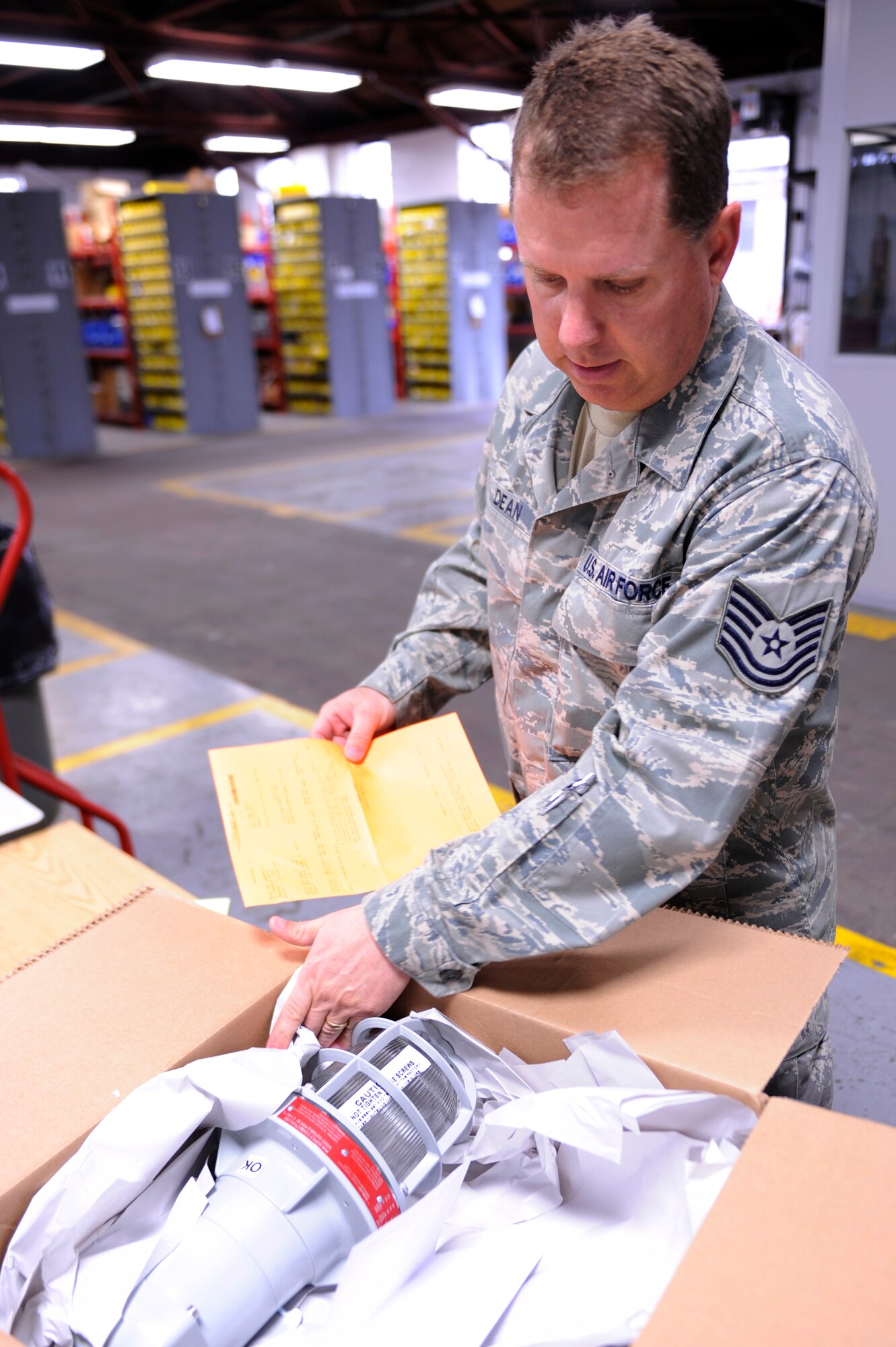 SCOTT AIR FORCE BASE, Ill -- Tech. Sgt. Christopher Dean, 375th Civil Engineer Squadron, Material Acquisitions NCO in charge, checks the condition of an explosion-proof light assembly that was just received, March 12, 2010 at Scott. The light assemblies are used in places where hazardous materials and fuels are stored. (U.S. Air Force photo/ Senior Airman Wesley Farnsworth)