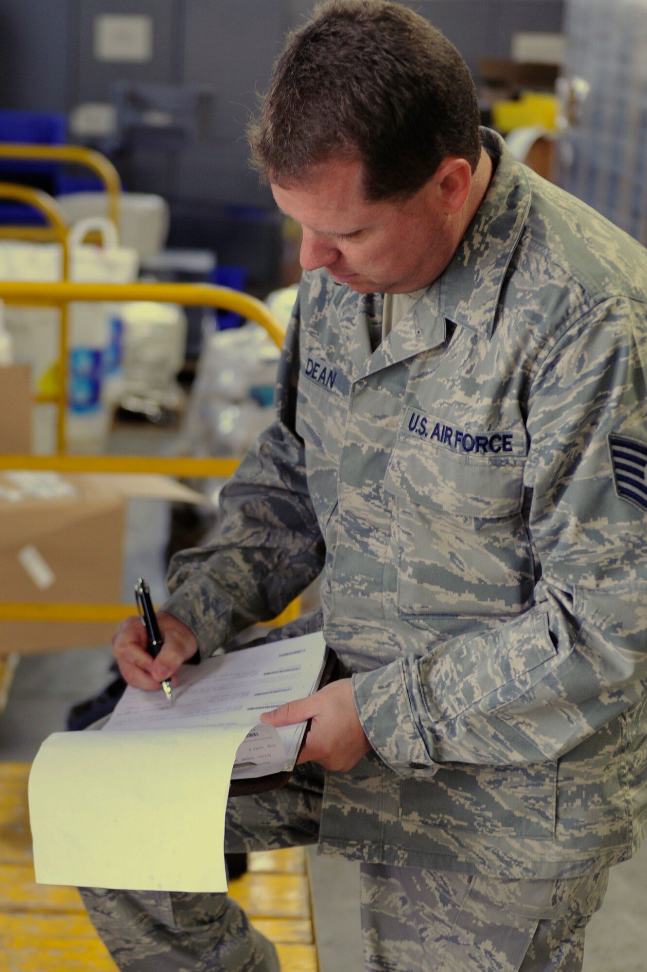SCOTT AIR FORCE BASE, Ill -- Tech. Sgt. Christopher Dean, 375th Civil Engineer Squadron, Material Acquisitions NCO in charge, signs for supplies inside their warehouse at Scott, March 12, 2010. Material Acquisitions supplies parts to approximately 130 Scott craftsmen. (U.S. Air Force photo/ Senior Airman Wesley Farnsworth)
