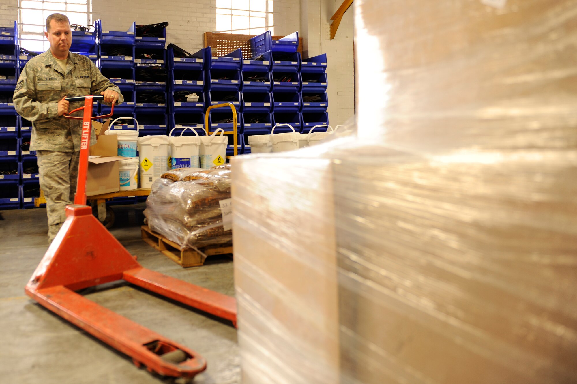 SCOTT AIR FORCE BASE, Ill -- Tech. Sgt. Christopher Dean, 375th Civil Engineer Squadron, Material Acquisitions NCO in charge, moves a pallet jack into place so the pallet can be moved for delivery, March 12, 2010 at Scott. Material Acquisitions is responsible for ordering and storing supplies needed to perform all minor maintenance for all 403 base buildings and the base infrastructure. (U.S. Air Force photo/ Senior Airman Wesley Farnsworth)