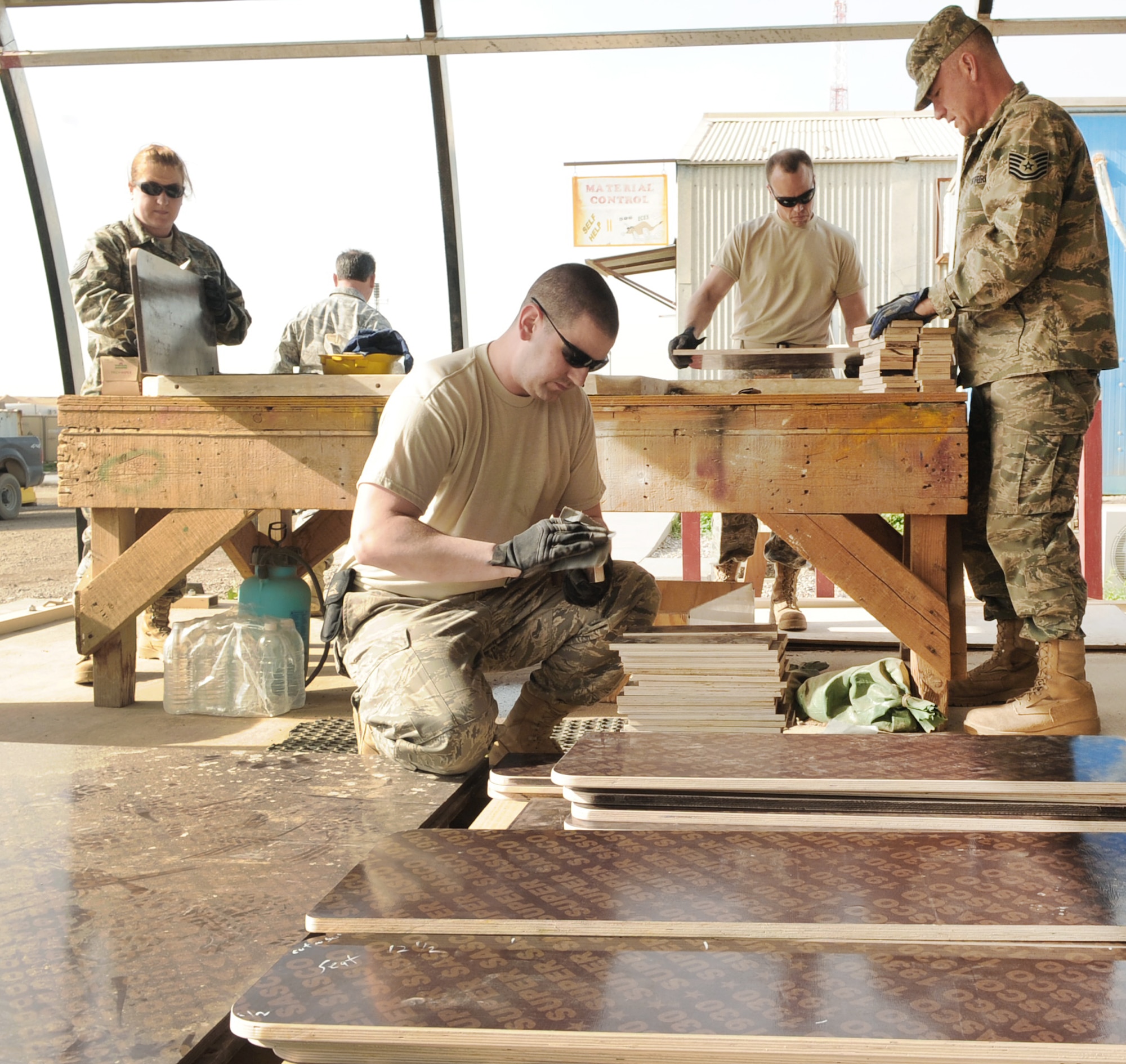 Volunteers from the 506th Expeditionary Civil Engineer Squadron sand down pieces of wood during assembly of school desks for local Iraqi children March 6, 2010, at Kirkuk Regional Air Base, Iraq. (U.S. Air Force photo/Staff Sgt. Tabitha Kuykendall)