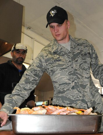 PANJSHIR PROVINCE, Afghanistan-- Air Force Airman 1st Class Joshua Lavrinc, Provincial Reconstruction Team Panjshir food services specialist, prepares crab legs to serve the members of PRT Panjshir at Forward Operating Base Lion. Airman Lavrinc, a Pittsburgh native and Penguin fan, is deployed to the Panjshir Province of Afghanistan where he will work for almost a year promoting security, governance and reconstruction efforts. (U.S. Army photo by Staff Sgt. Donald L. Reeves)
