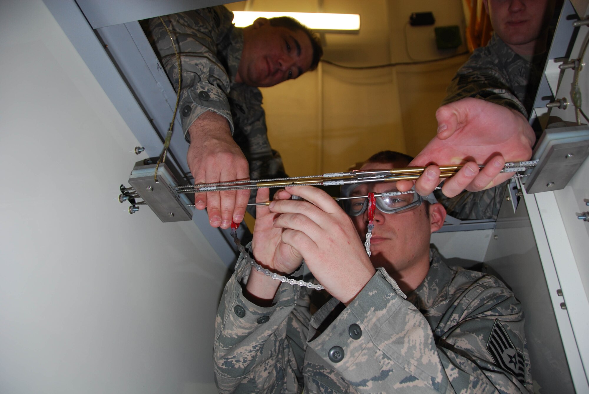 JOINT BASE MCGUIRE-DIX-LAKEHURST, N.J. - Tech. Sgt. Rob Danser, an aircraft structural maintenance specialist here, receives help from teammates as he's timed replacing a cable in preparation for the flight control rigging event at the upcoming AMTSociety Maintenance Competition. The competition is set for March 15-18 in Las Vegas, NV, and will showcase 25 maintenance teams from across the U.S. in 12 events vying for first place honors. (U.S. Air Force photo/Master Sgt. Donna T. Jeffries)