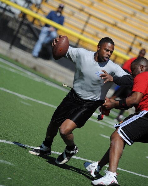 MOODY AIR FORCE BASE, Ga. -- Staff Sgt. Purnell Smith, 822nd Security Force Squadron military working dog handler, scrambles by a tackler during a flag football game held at the Valdosta Stadium in Valdosta, Ga., March 6. The Moody flag football team played against a Marine Corps team from Marine Corps Logistics Base in Albany, Ga. (U.S. Air Force photo by Airman 1st Class Benjamin Wiseman)