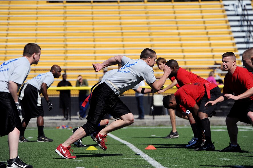 MOODY AIR FORCE BASE, Ga. -- Senior Airman Matt Mason, 23rd Logistics Readiness Squadron vehicle operator, along with other Flying Tigers, rush the defense after the hike during a flag football game at the Valdosta Stadium in Valdosta, Ga., here March 6. The flag football game was a challenge between Moody Airmen and Marines from the Marine Corps Logistics Base in Albany, Ga. (U.S. Air Force photo by Airman 1st Class Joshua Green)
