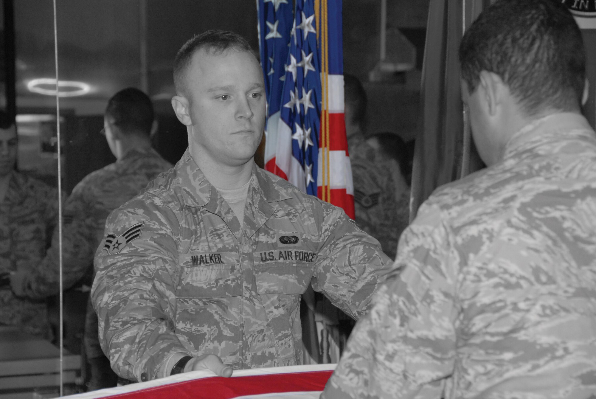 Senior Airman Zachary Walker leads the Whiteman Honor Guard in folding the flag during a ceremonial practice. Airman Walker, a Citizen Airman with the 442nd Fighter Wing, is a full-time member of the Whiteman Honor Guard. The 442nd Fighter Wing is an Air Force Reserve unit at Whiteman Air Force Base, Mo. (Photo and illustration by Senior Airman Danielle Wolf)