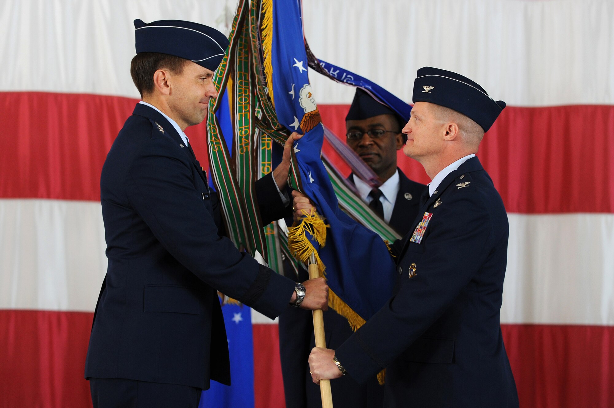 NELLIS AIR FORCE BASE, Nev --   Col. Dave Belote passes the guidon, symbolizing the relinquishing of command, to Maj. Gen. Stanley T. Kresge, U.S. Air Force Warfare Center commander,  during the 99th Air Base Wing change of command ceremony held at the Thunderbird hangar March 12. (U.S. Air Force photo by Tech. Sgt. Michael R. Holzworth)
