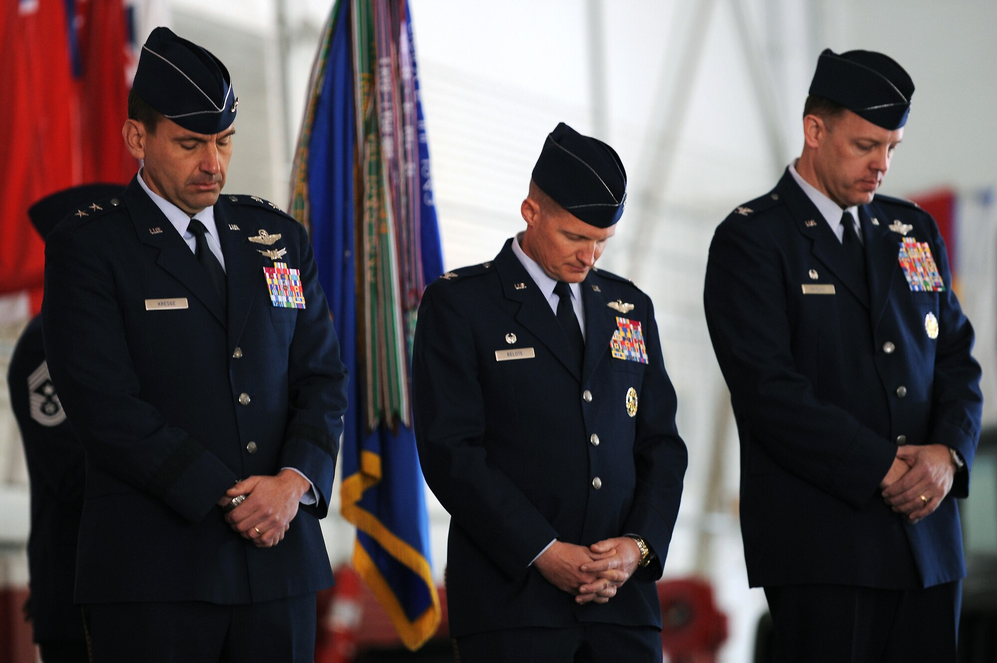 NELLIS AIR FORCE BASE, Nev --  Maj. Gen. Stanley T. Kresge, U.S. Air Force Warfare Center commander, Col. Dave Belote, 99th Air Base Wing commander, and  Col.  Steve Garland bow their heads in prayer during the invocation before the change of command ceremony held at the Thunderbird hangar March 12. (U.S. Air Force photo by Tech. Sgt. Michael R. Holzworth)
