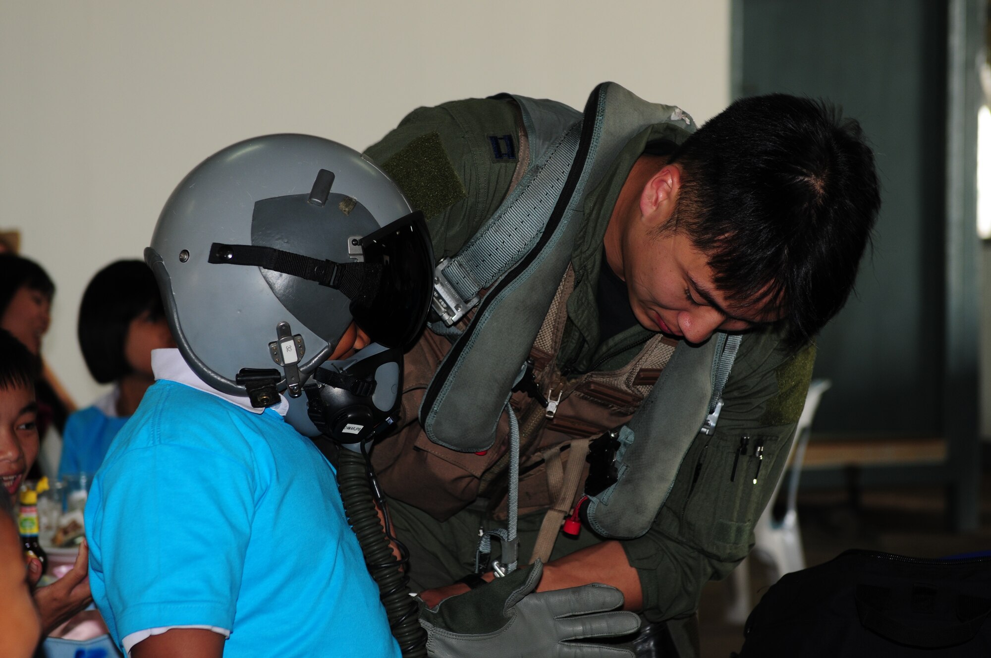 Capt. Albert Chang outfits a young Thai student with flight equipment during the Cope Tiger 2010 open house held for more than 50 Thai students March 10 at Udon Thani Royal Thai Air Force Base, Thailand. Captain Chang is a pilot from the 25th Fighter Squadron at Osan Air Base, South Korea.  (U.S Air Force photo/Capt. Genieve David)